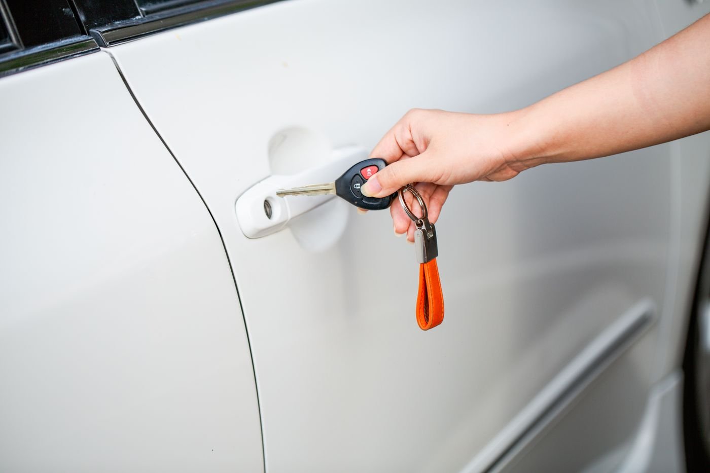 Car key held beside a locked car door